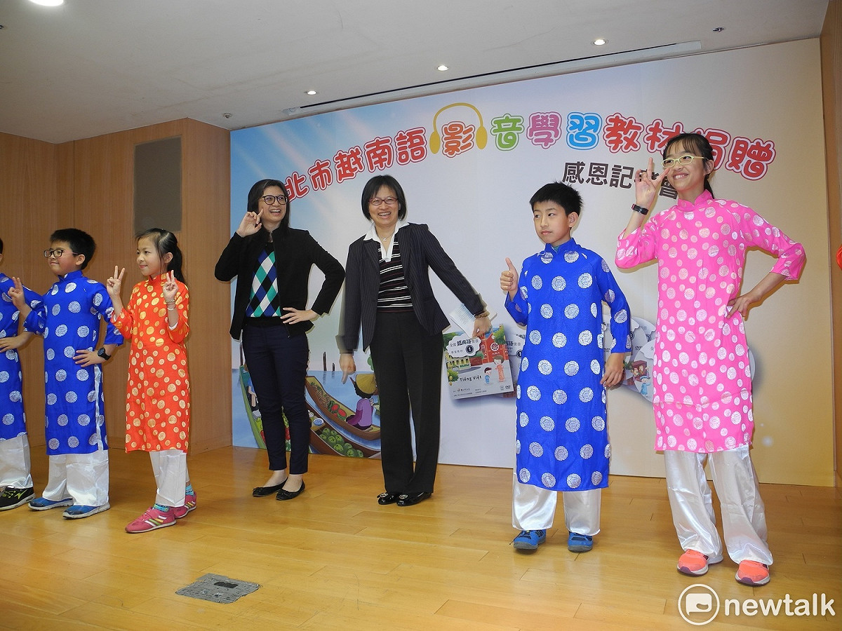新北市教育局副局長黃靜怡 (右四)、美商摩根大通集團代表 (右三) 與新住民子女表演越南歌謠。 圖: 王峻昌/攝