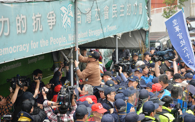 反軍人年改團體27日下午持續抗爭，拆除濟南路獨派團體帳篷上的旗幟並燒毀，打算拆第二面旗幟時，與警方爆發衝突。 圖 : 中央社