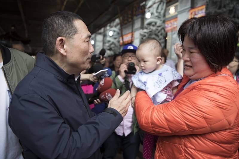 遇上帶著可愛嬰兒的熱情媽媽，侯友宜笑著說，「可以讓我抱一下嗎？」還不忘稱讚媽媽跟寶寶都一樣皮膚白又漂亮。 圖:侯友宜辦公室 / 提供