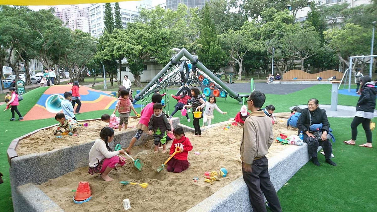 複合式沙坑台是不同於傳統沙坑平接於地面，不用弄髒褲子就輕鬆地玩沙，而高台沙坑區能讓乘坐輪椅的孩童也可以親近享受玩沙的樂趣，還貼心的設置遮陽帆布及洗腳區，讓玩沙體驗變得更加輕鬆愉快。 圖：台北市工務局提供