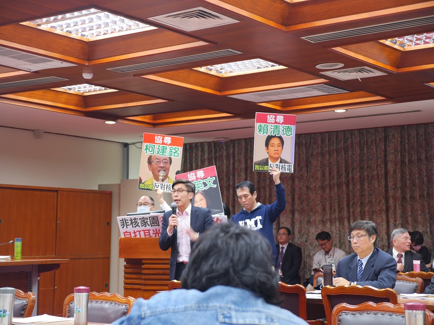 當進入質詢時，國民黨立委持續盤踞未下台，讓民進黨立委鍾佳濱在抗議告示牌前質詢。 圖：趙婉淳／攝