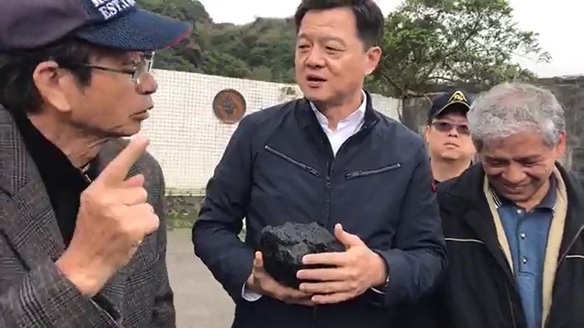 周錫瑋與深澳地區的居民在深澳電廠前開直播，秀出煤塊討論燃煤的汙染；居民怒批賴揆騙台灣郎。 圖：翻攝自周錫瑋臉書