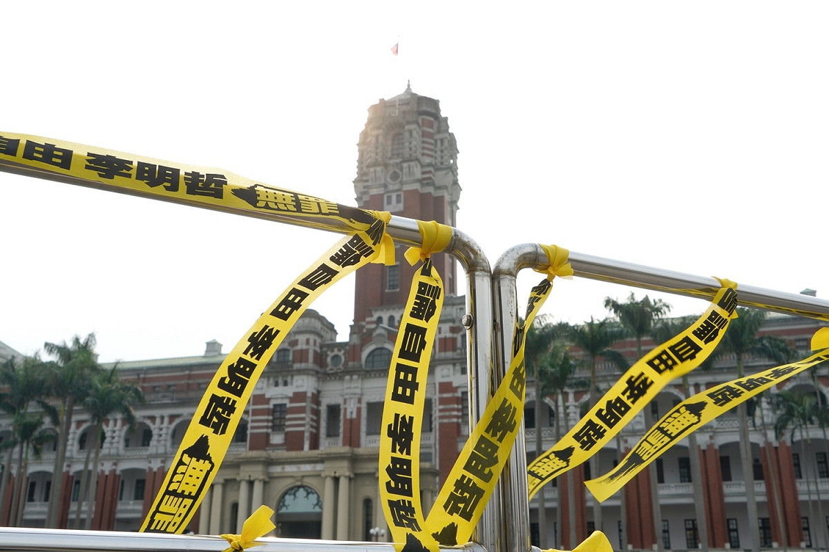 李明哲救援大隊19日在總統府綁上黃絲帶。 圖：張良一/攝