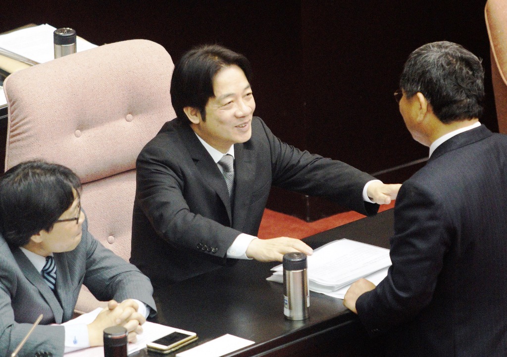 行政院長賴清德上午在立法院議場和民進黨籍立委陳明文愉快的交談。台灣民意基金會昨公布民調顯示，賴清德施政滿意度比小英總統高出兩成。 圖：張良一/攝