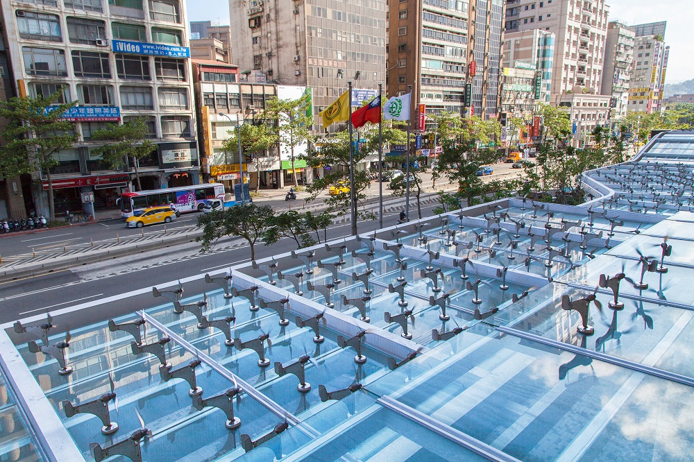 台電將大樓周遭出名的「掀裙風」(風切)，利用雨遮裝置上百隻小風機打造低碳開放公共藝術，除可遮風避雨，更可「風力發電」點亮美麗夜晚。 圖：台電／提供