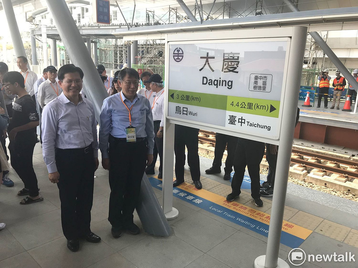 台中市長林佳龍與台北市長柯文哲跟台鐵大慶站的站牌合影。 圖：周煊惠 / 攝
