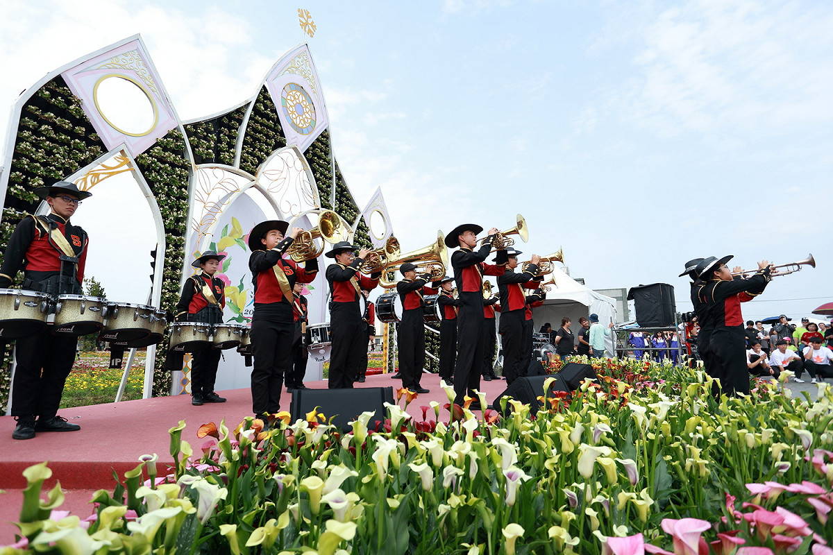 桃園新興高中樂旗隊、溪海國小等團隊扮裝輪番演出踩街遊行，現場氣氛熱鬧，吸引現場遊客紛紛租借婚紗加入。 圖：桃園市政府農業局／提供