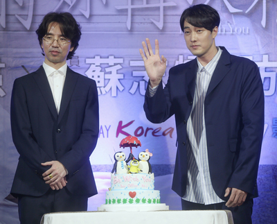 韓星蘇志燮（右）與導演李章焄（左）來台宣傳新片「雨妳再次相遇」，27日晚間在台北出席電影首映會，現場並準備特製蛋糕，祝福電影票房開紅盤。 圖 : 中央社