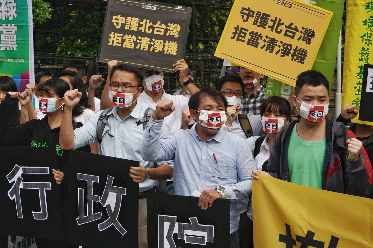 多個環保團體成員口戴白口罩在行政院前請願，要求行政院長賴清德退回深澳電廠環評案。 圖：張良一/攝