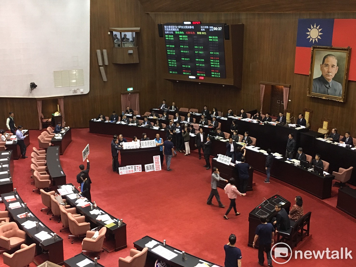 國民黨立院黨團今（30）早手持抗議標語佔領發言台，並祭出報告事項表決戰癱瘓議事。 圖：黃韋銓/攝