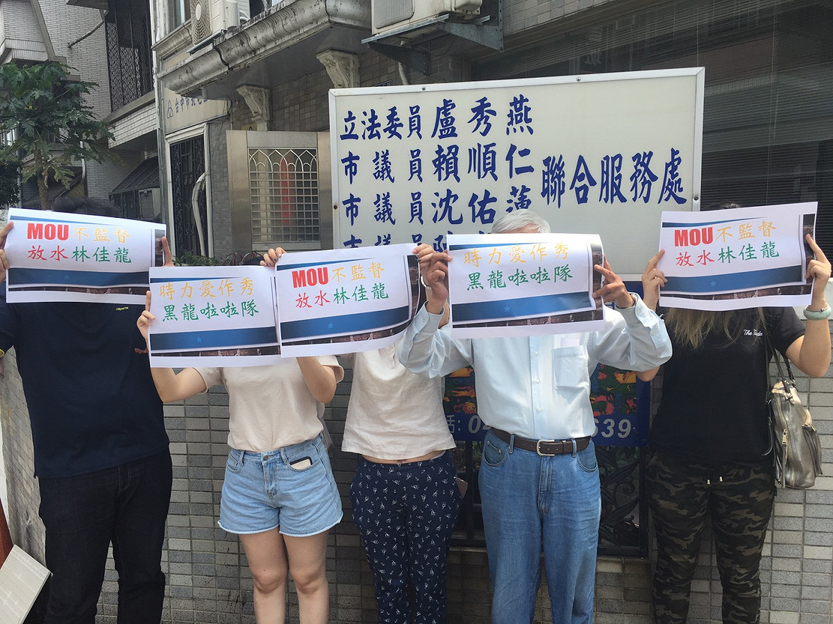 國民黨北屯區黨部人員持手板反嗆時力議員參選人，為何不去監督林佳龍。 圖：國民黨北屯區黨部/提供