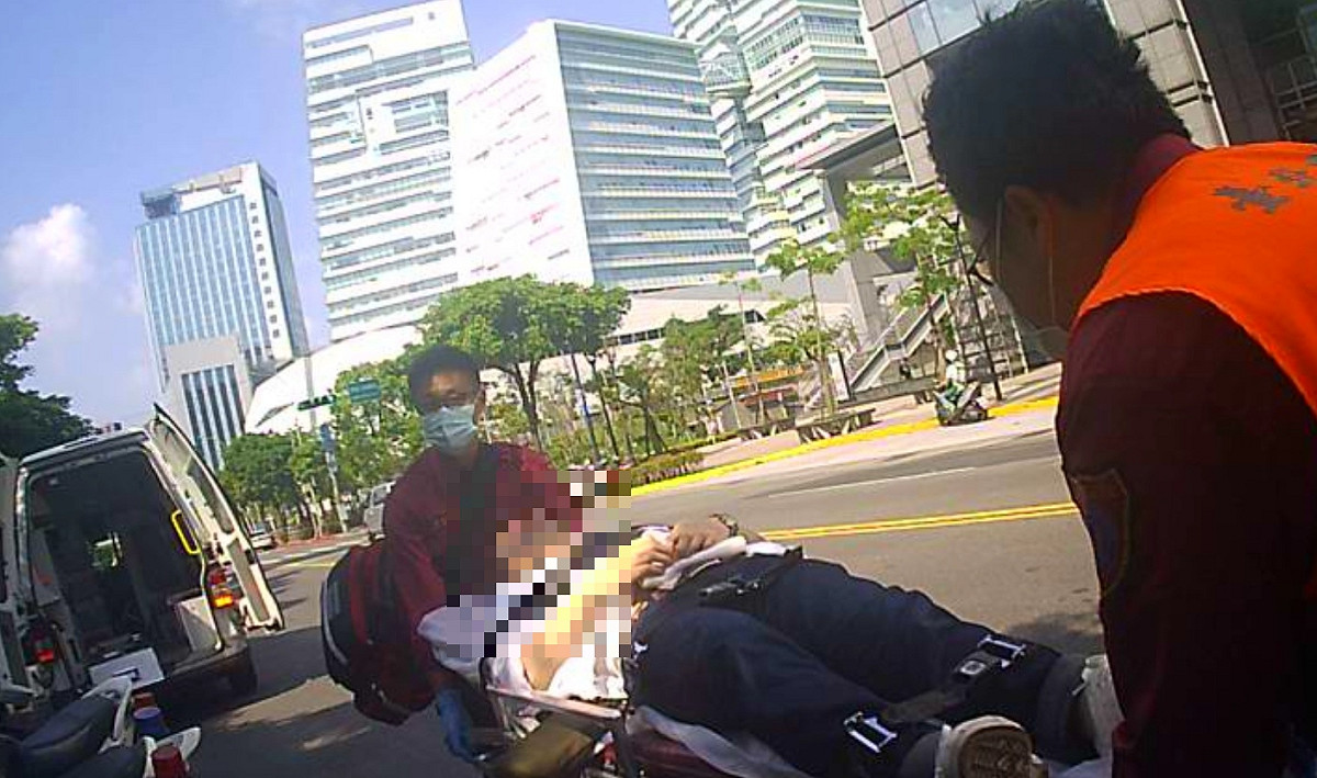 日籍男子欲為女模周盈欣切腹，救護人員將該日籍男子抬上救護車並送醫診治。 圖 : 台北市警局/提供