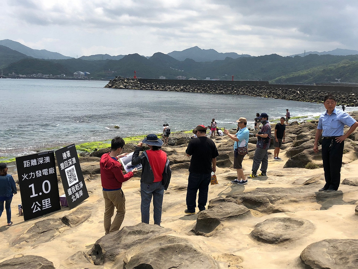 綠色和平今（5）日與當地居民共同前往知名景點象鼻岩，透過面對面的溝通方式告訴遊客，即將興建的深澳燃煤電廠，距離象鼻岩僅1公里。 圖：綠色和平提供