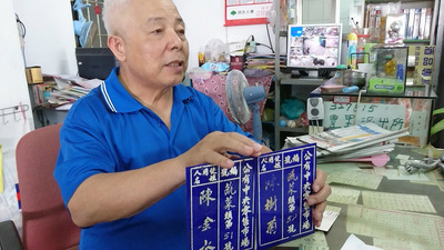台東善心菜攤阿嬤陳樹菊的弟弟陳洽銘拿出這幾天在她的「員金菜攤」找到的兩個市場攤位牌照，陳洽銘說：「這賣菜的牌子已經50幾年了。」 圖：中央社