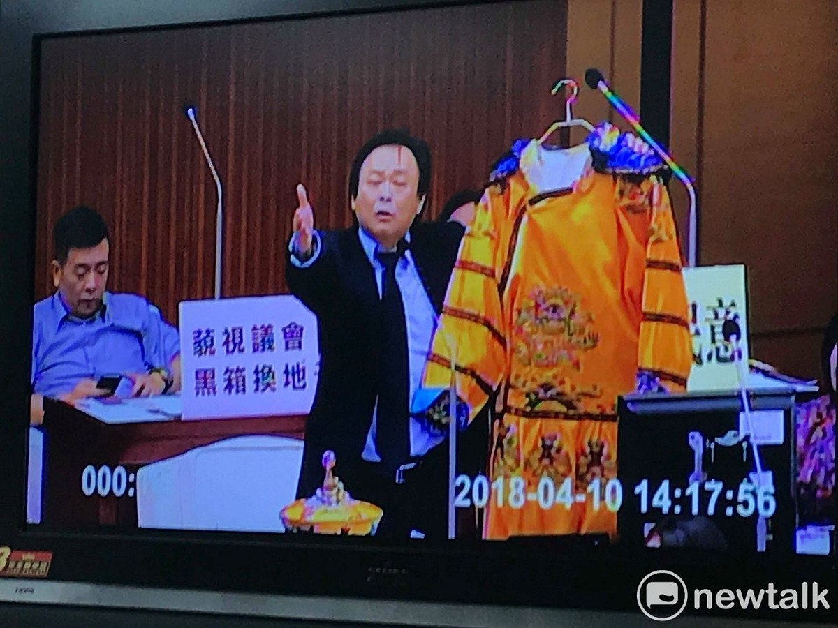 民進黨台北市議員王世堅贈送龍袍給台北市長柯文哲。 圖 : 周煊惠翻攝議會轉播畫面