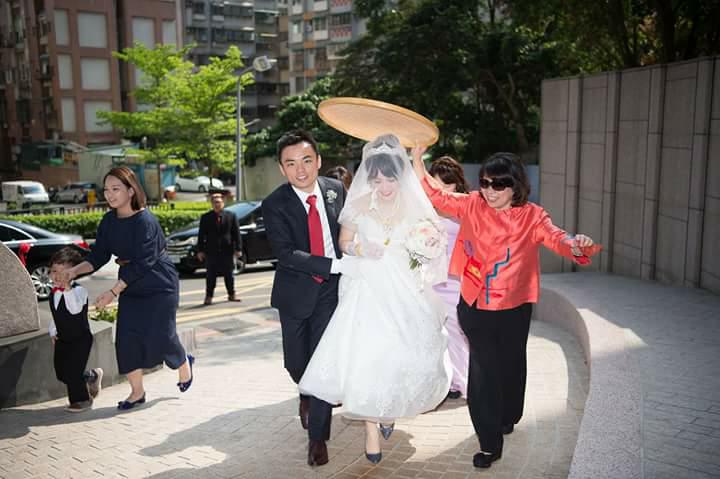 黃敏惠當起媒人婆，手持米篩為新娘遮陽，有趨吉避凶之意。 圖：婚禮攝影師洪年宏/提供