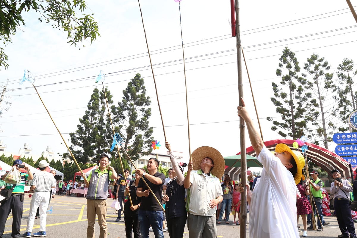 張花冠和多位議員人手一支竹竿採芒果。 圖：嘉義縣政府/提供