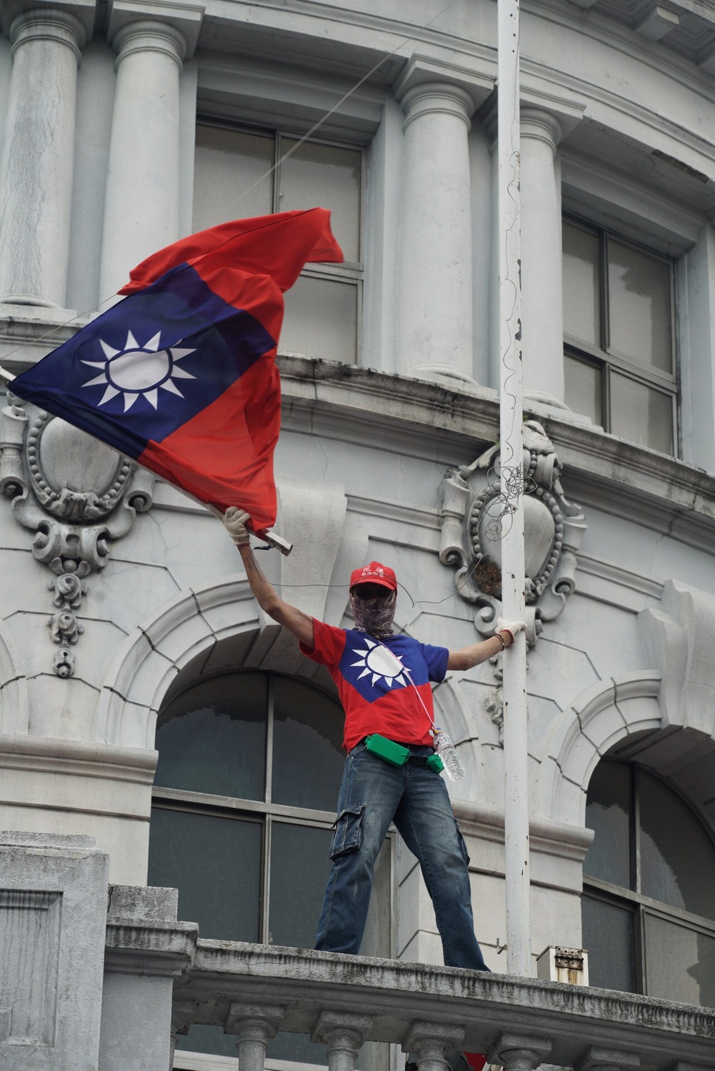 有遊行民眾爬上監察院陽台揮舞國旗。 圖：張良一/攝