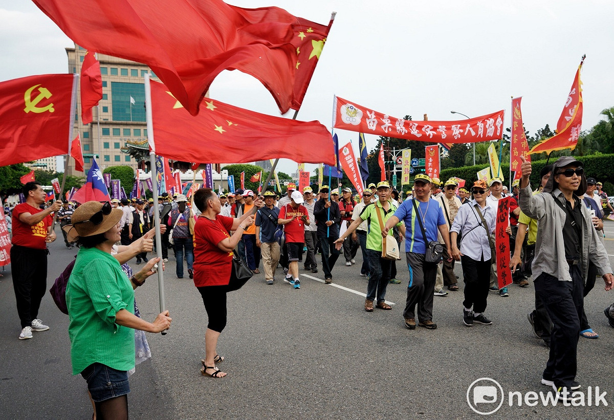 退休軍公教警消團體今天走上街頭，也有人拿著統促黨的旗子揮舞。 圖：張良一／攝