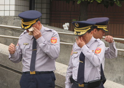 國道公路警察局第四公路警察大隊兩名殉職員警25日移靈，車隊繞行至兩人所屬的新市分隊，逾百名員警淚眼送行，儀式結束後頻頻拭淚。 圖：中央社
