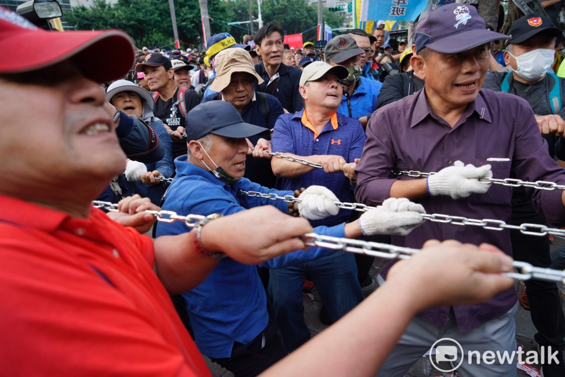 反年改團體拿出鐵鍊和鐵勾破壞拒馬和立法院大門。 圖：張良一／攝