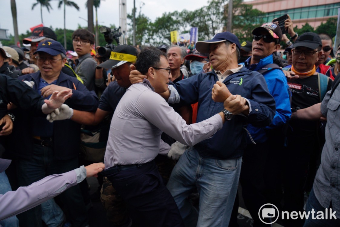 八百壯士襲警，一名警察被反年改人士粗暴拉扯，另一名警察從後方拉住他。 圖：張良一/攝