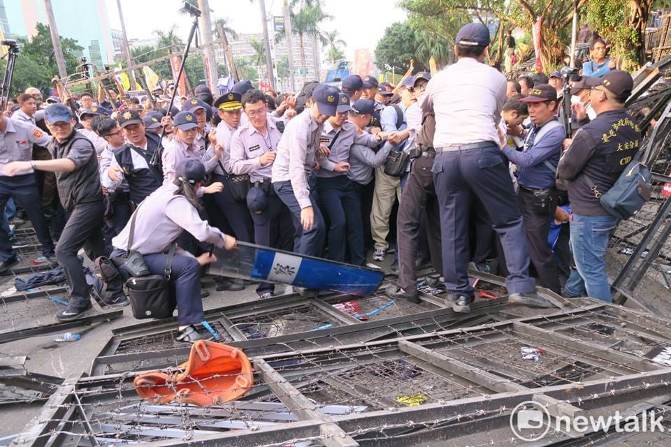 一陣推擠結果，女警趕緊拿盾牌遮住拒馬，避免有人掉落被刺到。 圖：邱萬興／攝