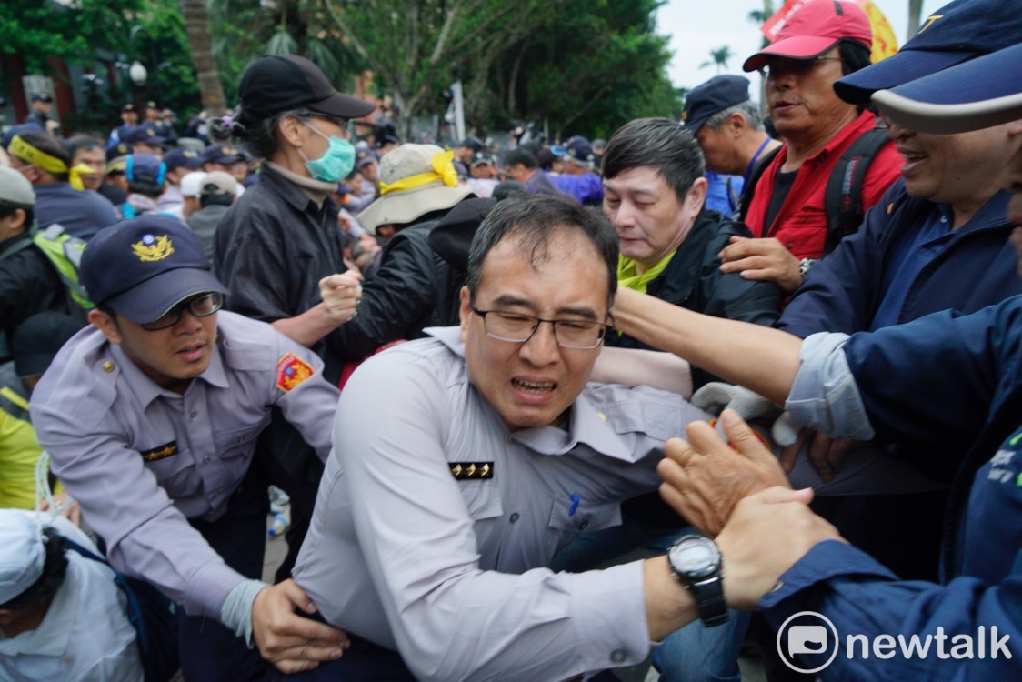 多名反年改人士拉住該名警察。 圖：張良一/攝