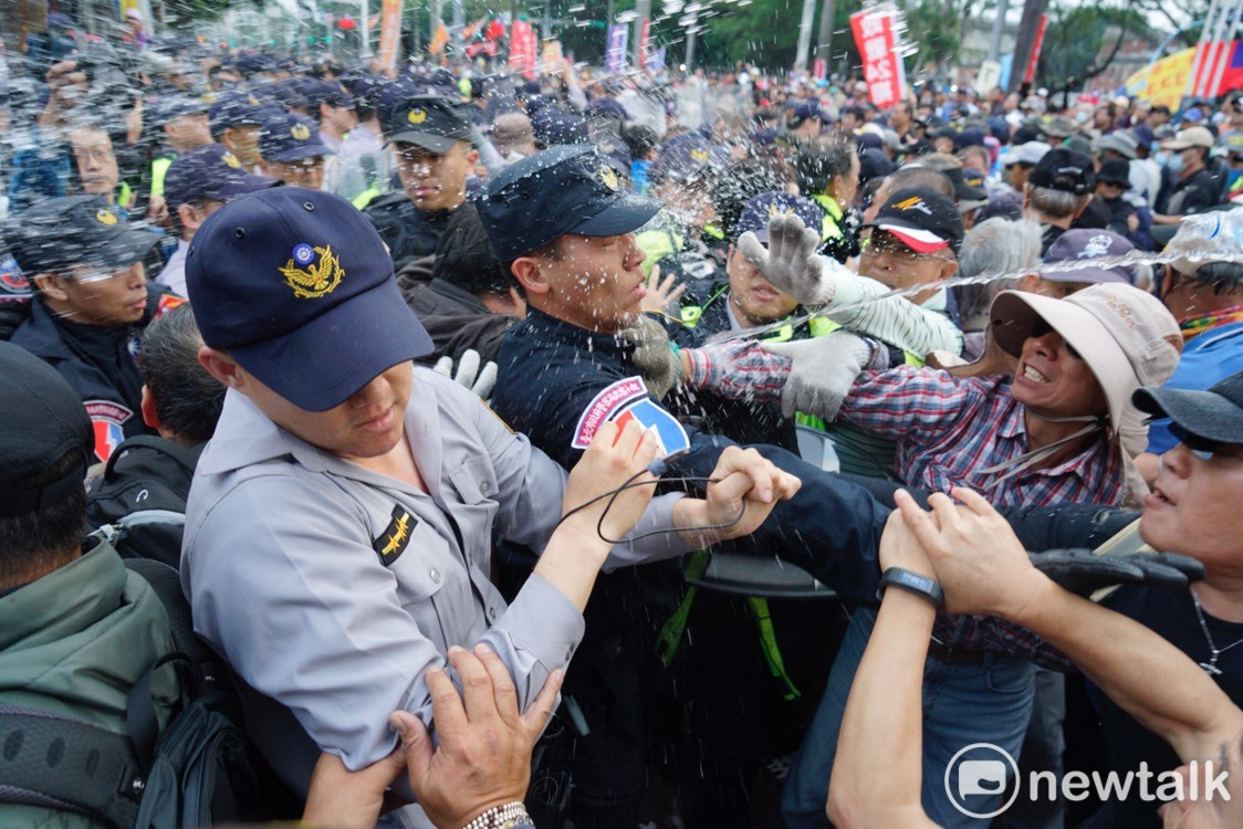 反年改人士向警察潑水。 圖：張良一/攝