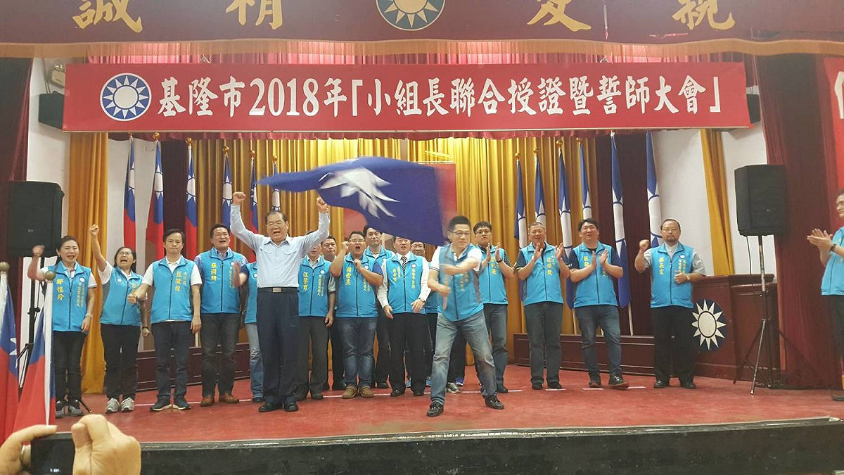 國民黨基隆市長參選人謝立功從國民黨副主席曾永權手上接下黨旗，誓言將再讓國民黨在基隆叢綠地變回「藍天」。 圖：國民黨基隆市黨部 / 提供