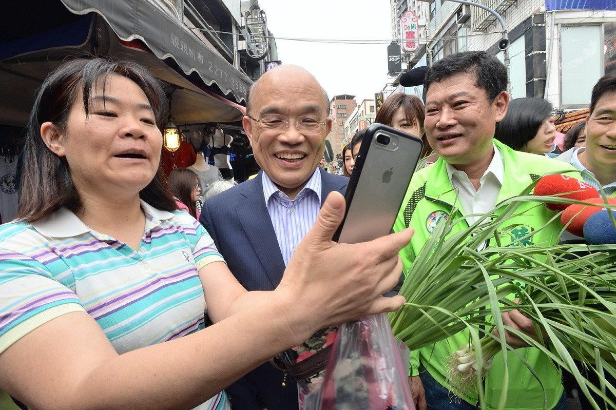 蘇貞昌訪問新北市廟宇，民眾搶著合照，蘇也買蒜頭分贈市議員參選人預祝凍蒜。 圖 : 蘇貞昌競選辦公室/提供