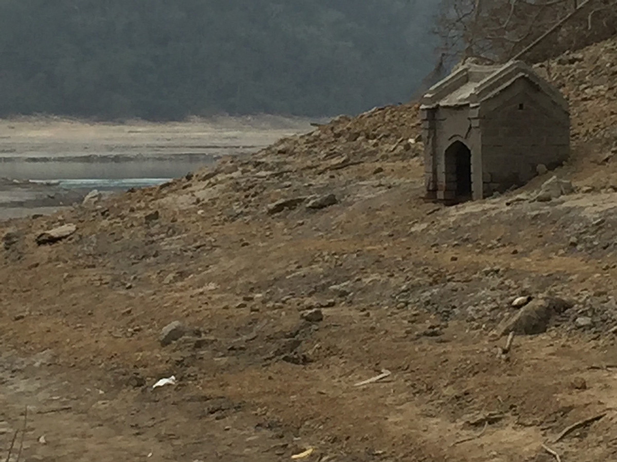 沉沒在石門水庫集水區內的土地公廟，今年首次露出水面，水位不斷下探，目前水位在235公尺左右。 圖:北區水資源局/提供