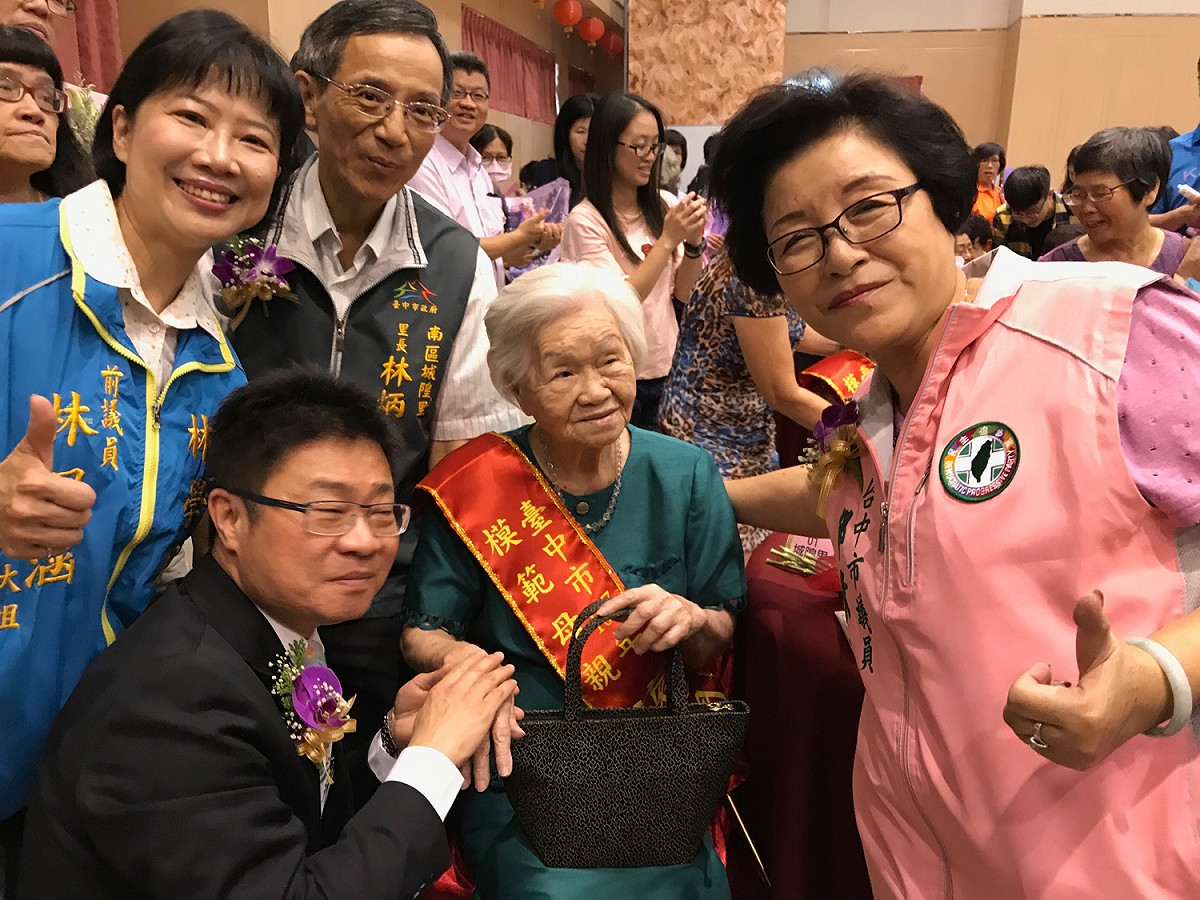 社會局長呂建德替模範母親擦護手霜。 圖：南區區公所/提供