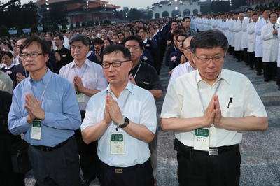 台北市長柯文哲（前右）13日晚間在台北出席慈濟基金 會2018年佛誕浴佛孝親感恩祈福會，和與會各界人士一 同雙手合十祈福。 圖：中央社