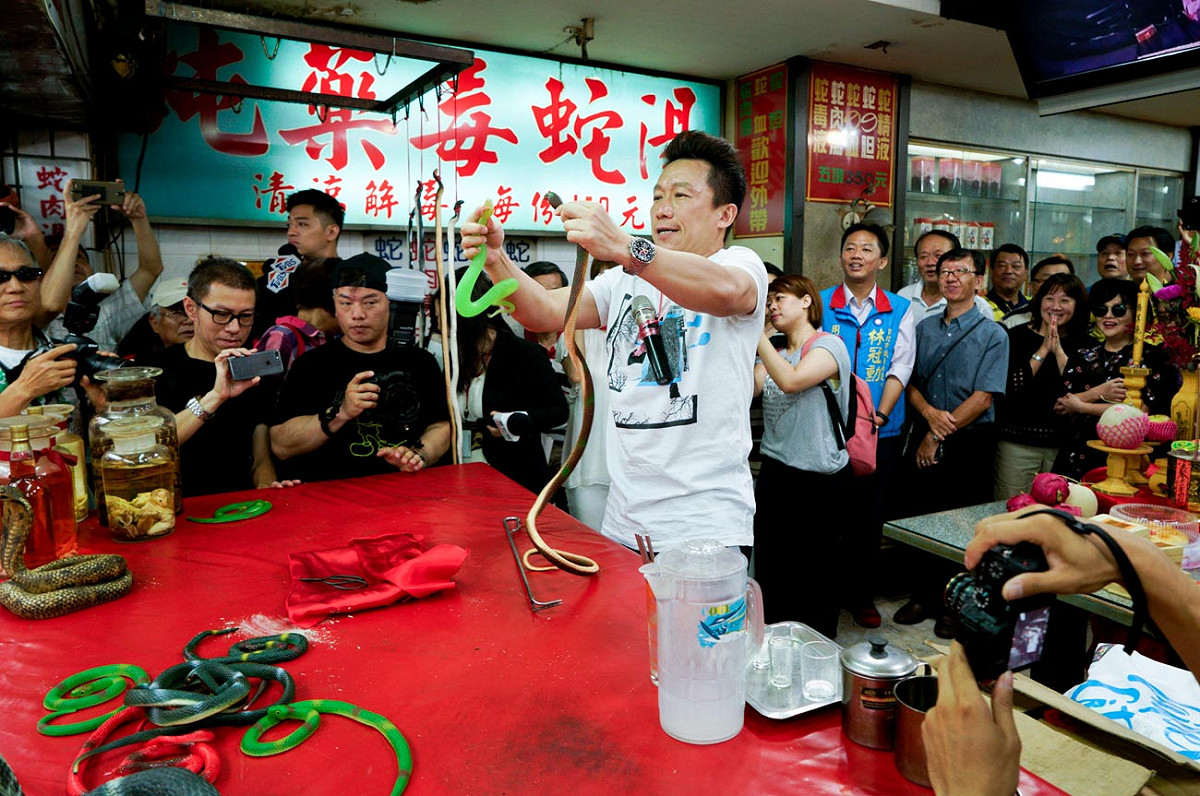 模仿叫賣殺蛇秀極富盛名的藝人郭子乾再度拿出殺蛇秀絕活，讓現場民眾看得哈哈大笑。 圖：張良一/攝