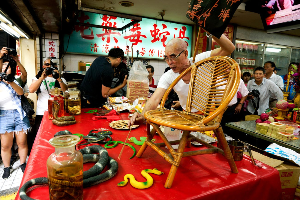 一位師父在亞洲蛇肉店內，為店內的蛇靈祈福，讓牠們跟著地藏王菩薩各歸其位。 圖：張良一/攝