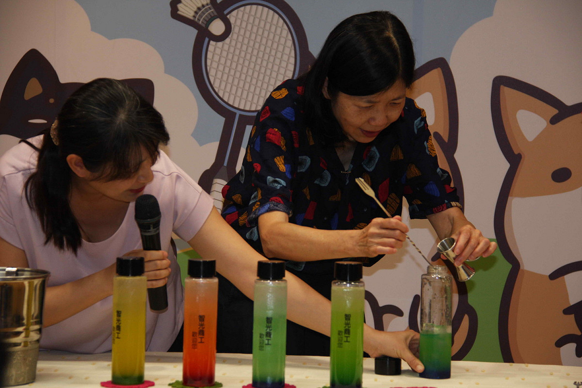 新北市副市長呂衛青與智光商工學生共同調製多彩漸層的飲料，介紹職業試探育樂營。                
 圖：王峻昌/攝