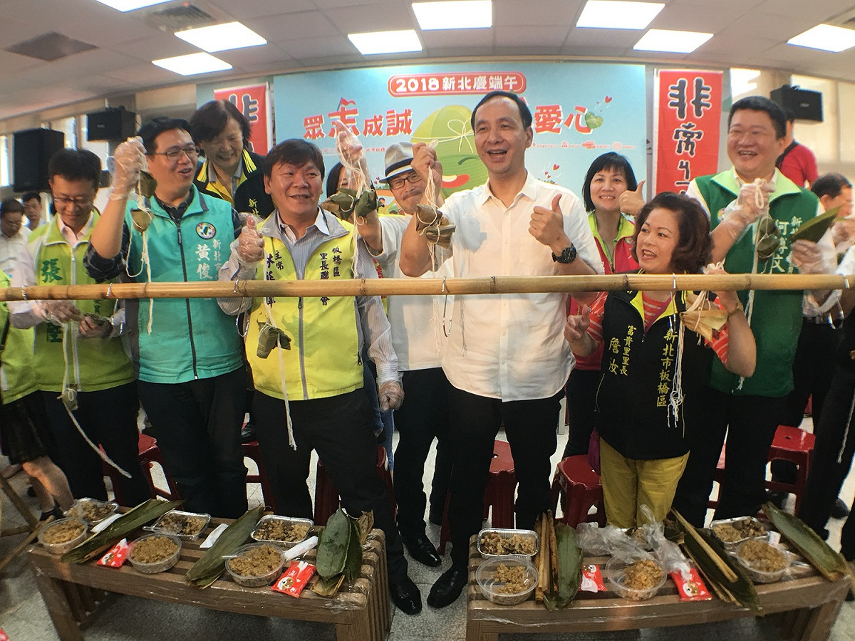 朱立倫與包愛心粽的民代、里長，一起展示包粽成果，有趣的是，在場民代全是民進黨籍。                    
 圖：板橋區公所提供