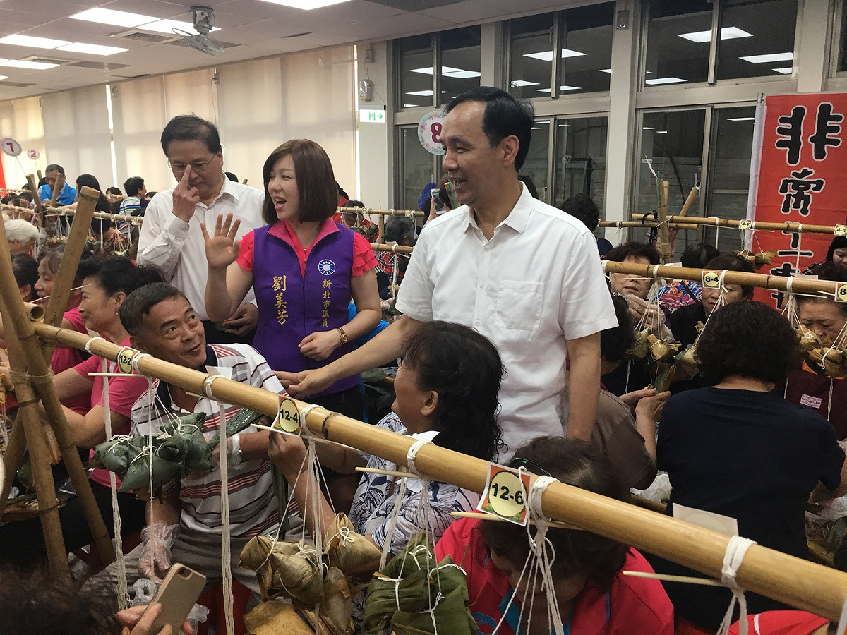 國民黨議員劉美芳（中）在板橋區公所愛心粽活動結束前趕到，與市長朱立倫、區長林敬榜一起看志工包粽成果。
 圖：板橋區公所提供