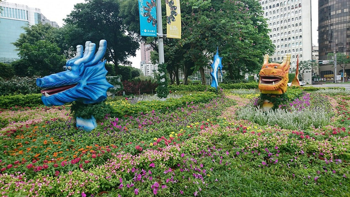 台北市工務局公發揮創意，用小百日草、矮牽牛、夏堇花卉布置仁愛圓環，並配合端午設置兩隻色彩繽紛的龍舟。 圖：台北市政府提供