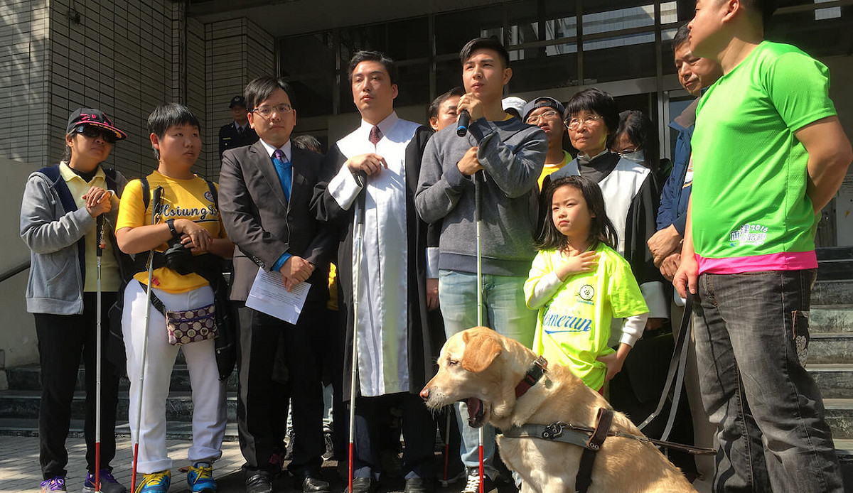 原名陳敬鎧 (中持麥克風者) 的前手球國手陳宥憲涉裝瞎詐保險金案，高雄地檢署原通知今天發監執行，陳男報到後，檢察官考量已聲請再審和聲明異議，准予暫緩執行。 圖 : 翻攝自司改會網頁