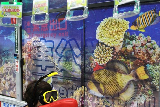 公車內裝則以在海底潛水的概念為主軸，藉由珊瑚、魚群及海浪激起的浪花營造海底景致，車內天花板更有海豚在頭頂悠遊，運用「海底世界景致」塑造超現實的「空間錯覺」。  圖：高雄市交通局/提供