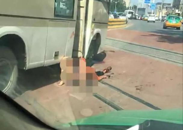 西安驚傳公車隨機砍人，一對疑為母子的傷者倒臥在公車旁。 圖/翻攝自微博