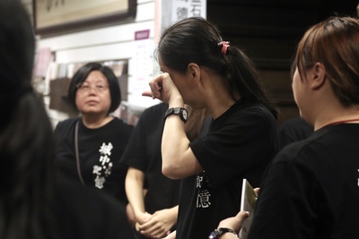知名連鎖書店品牌金石堂城中店因租約到期、房東不續租，24日晚間10時正式結束34年歷史。熄燈後，幾名員工不捨落淚。 圖：中央社