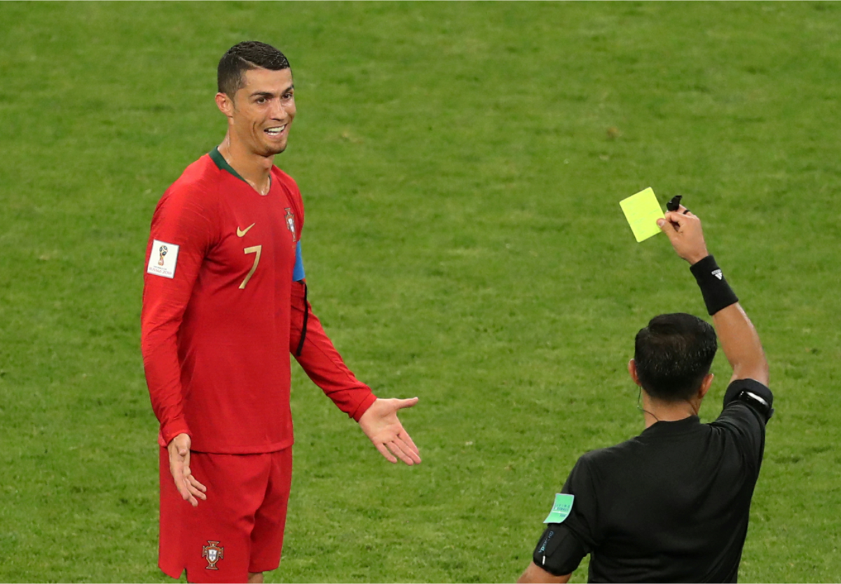葡萄牙王牌「C羅」羅納度（Cristiano Ronaldo，左）在小組賽前2戰共踢進4球，包辦全隊所有進球，今天他被對手鎖死、幾乎沒有太多進攻機會。圖為C羅犯規拿了一張黃牌，兩手一攤，露出尷尬一笑。 圖：達志影像/路透社