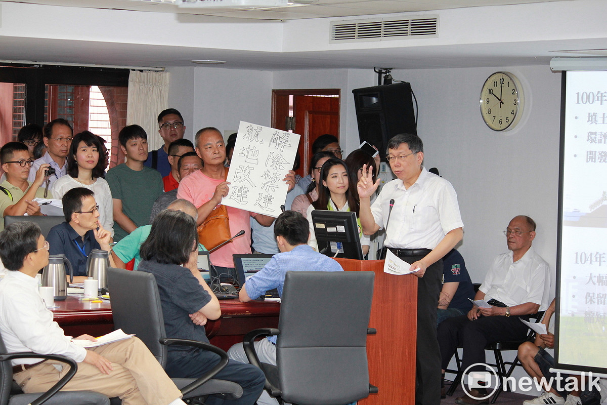 台北市長柯文哲今（26）日出席內政部審議社子島都市計畫委員會，現場有民眾舉牌「解除禁建、就地改建」。 圖 : 周煊惠 / 攝
