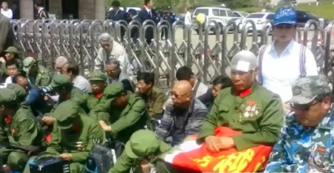 老兵們大部份身穿迷彩軍服，拿着國旗，叫着「改善老兵生活」口號。一些抗議老兵手裏舉著紅色標語，上面寫著「我們是共產黨員，不是罪犯」。 圖：翻攝自網路