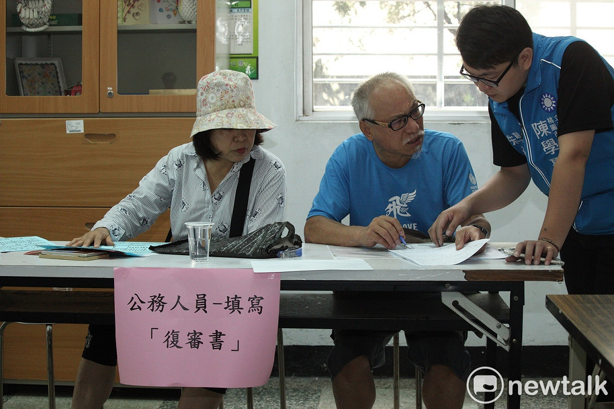 工作人員正為民眾說明如何填寫公務人員專用的復審申請書。 圖：林昀真/攝