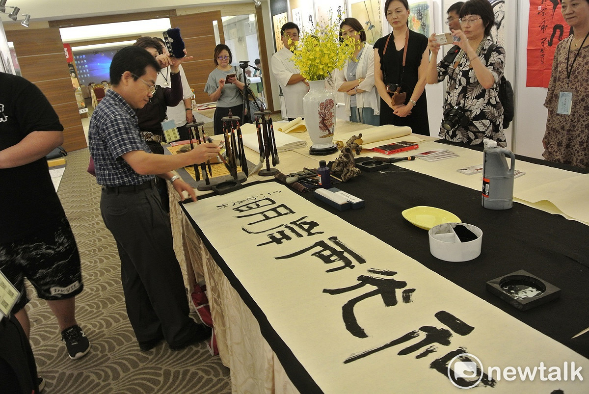 南投縣文化局長林榮森為兩岸筆會「開筆」，寫下「日月和光兩岸明」。 圖：唐復年/攝