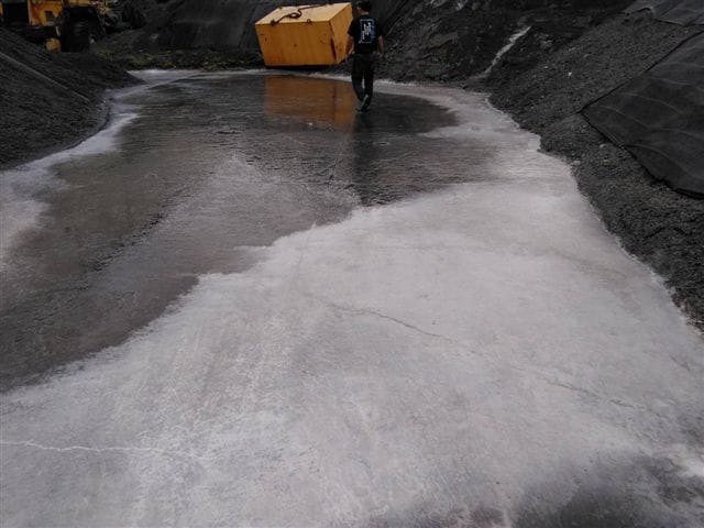 地勇公司廠區積水而導致堆放產品的pH值將近12的強鹼性乳白色廢水逸出廠外造成污染。 圖：高雄市環保局/提供